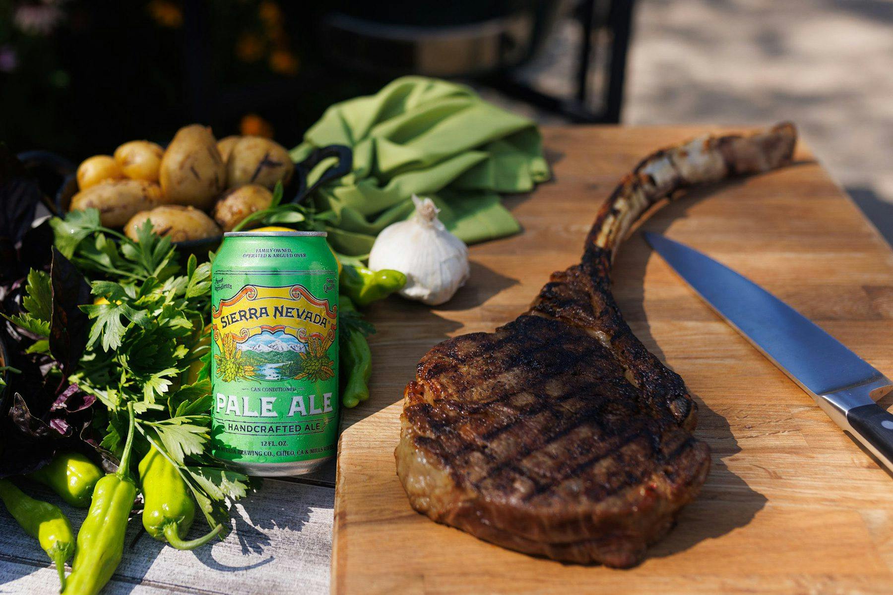 A can of Sierra Nevada Pale Ale next to a grilled tomahawk steak resting on a cutting board