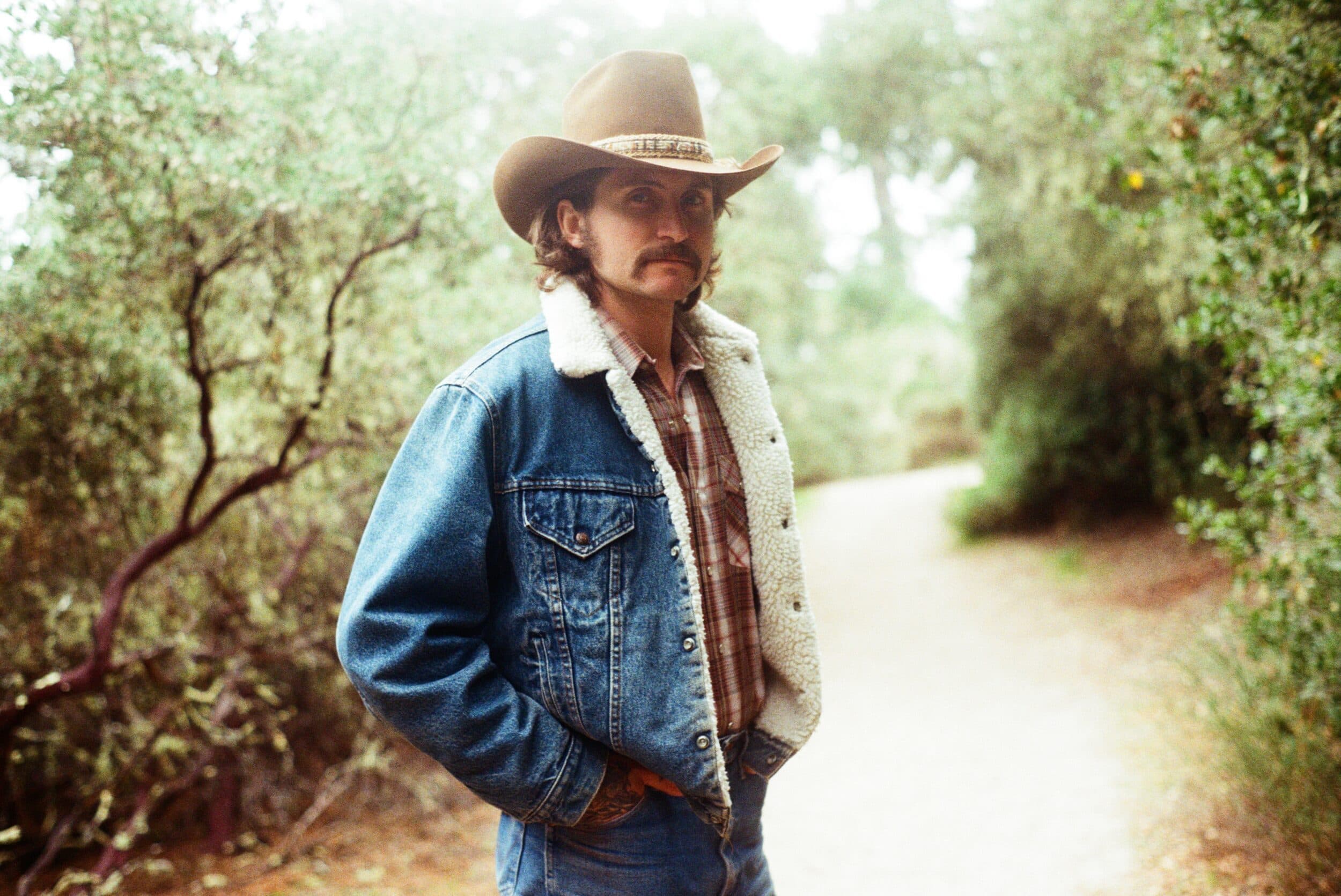 Jesse Daniels standing on a trail in the woods