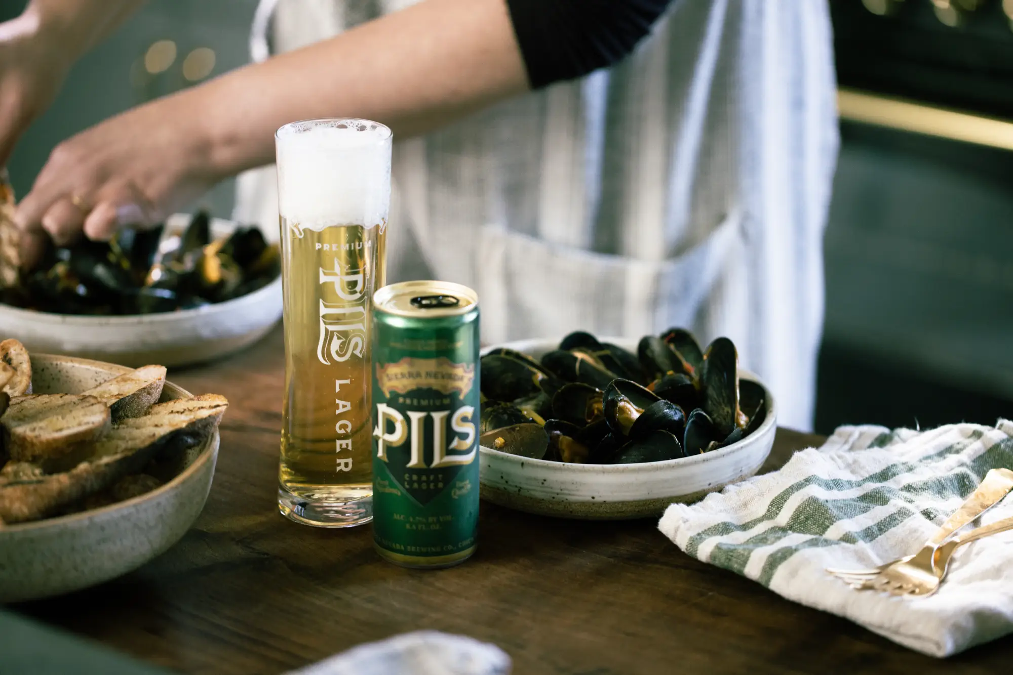 PILS in can and glass next to bowl of steamed mussels.